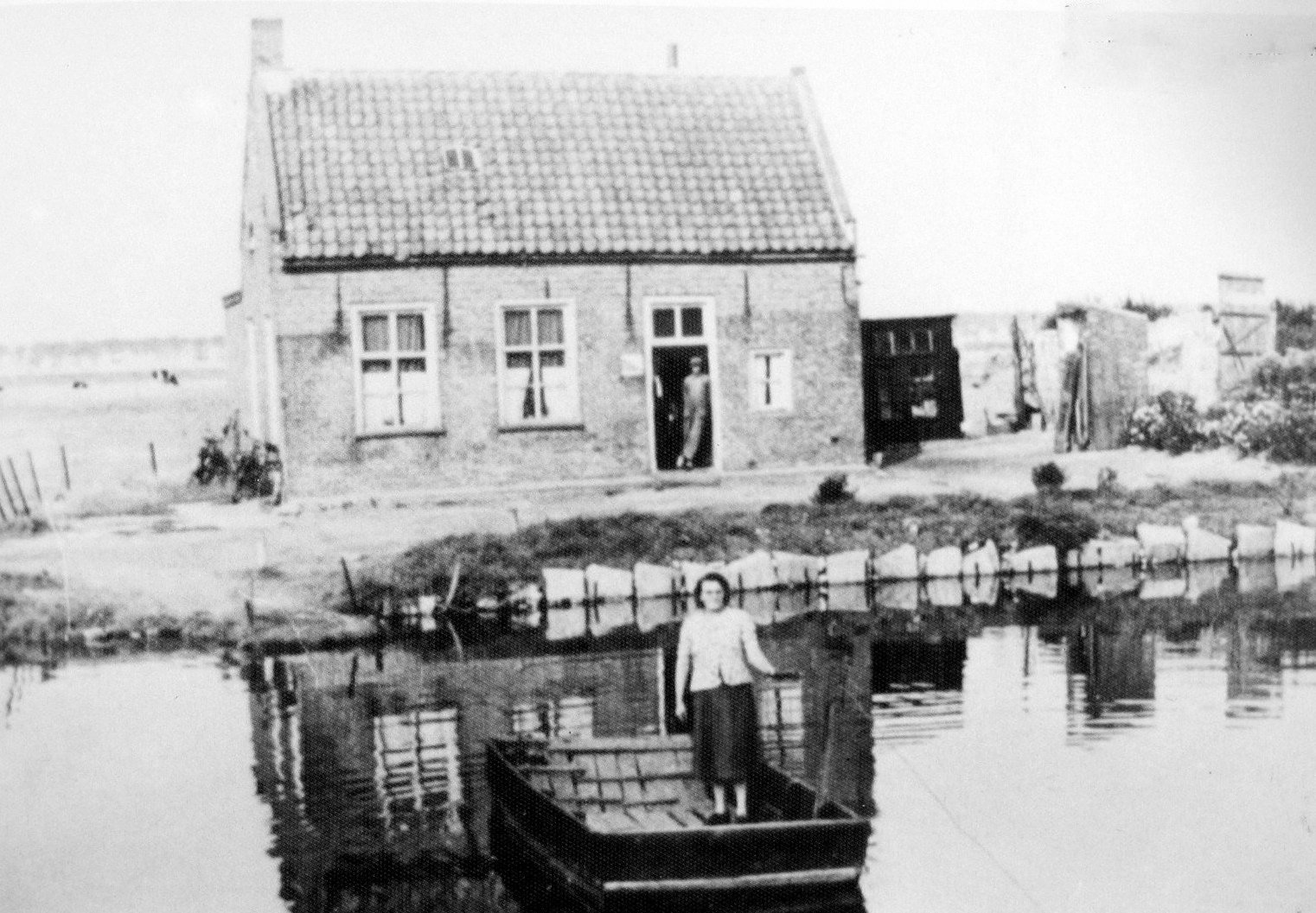 Tonia van 't Veer (mevrouw de Jong- Jongeneelen) op het pontje voor het Veerhuis, jaren 1950. Tot 1960 werd je voor 5 cent naar de overkant gebracht. In 1960 stopte Tonia en daarmee het voetpontje. Foto: Juffrouw Heijnen